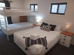 une chambre avec deux lits et un lit superposé dans l'établissement Huge Home, 9 Bed, 6 Bath, Sleeps 22, Central Location, Walk to Shops, à Jindabyne