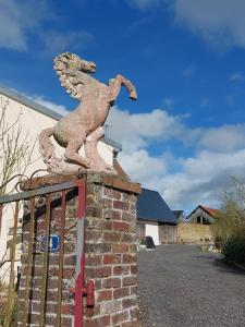 una estatua de un caballo sobre una pared de ladrillo en Chambre table d'hôtes Anne-Marie et Jean-Christophe, 