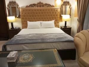a bedroom with a large bed and two lamps at Hotel Luxe Heights Lahore in Lahore
