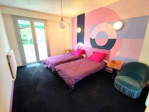 Zimmer mit 2 Betten und einem Stuhl in der Unterkunft Gite LE 45 TOURS in Nueil-sous-les-Aubiers