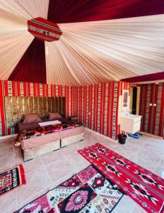 ein Schlafzimmer mit einem Bett und zwei Teppichen auf dem Boden in der Unterkunft Rum Aranda camp & Jeep Tour in Wadi Rum