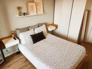 um quarto com uma cama com uma almofada preta em JO 2024 proche Stade France et Paris Ligne 14, 13 em Saint-Ouen