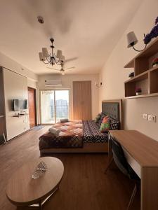 een slaapkamer met een groot bed en een tafel bij Crystal box NIMBUS Noida expressway in Noida