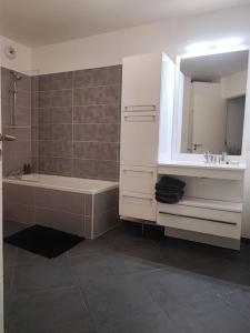uma casa de banho com uma banheira, um lavatório e um espelho. em JO 2024 proche Stade France et Paris Ligne 14, 13 em Saint-Ouen