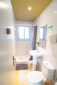 a white bathroom with a toilet and a sink at Carving Surf Hostel in San Esteban de Pravia