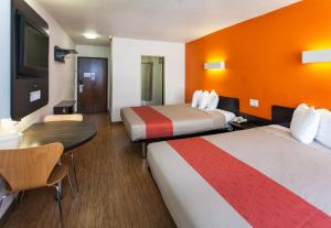 Habitación de hotel con 2 camas y mesa en Motel 6 Hollywood en Los Ángeles