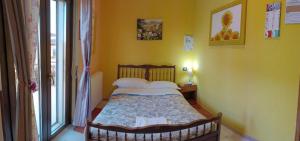Complesso turistico Aurora - camere B&B في Poggio Picenze: غرفة نوم بسرير وجدران صفراء ونافذة