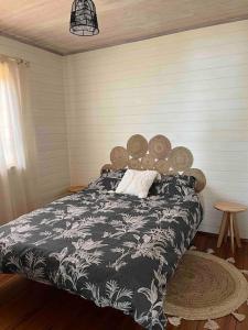 een slaapkamer met een bed met een zwart-wit dekbed bij Mountain house with sea view in Ítrabo