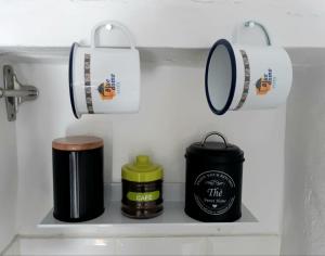 ein Regal mit Tassen und einem Spiegel im Bad in der Unterkunft Cute and characterful townhouse in Oliva