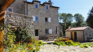 a stone building with a bench in front of it at Gite les ducs in Mialanes