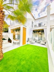 une grande cour avec une pelouse verte dans l'établissement Luxury villa Fanabe with private garden, à Adeje