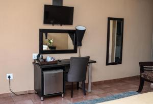 a desk with a lamp and a mirror on a wall at Thaba Legae Guest Lodge in Rustenburg