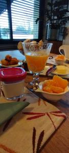 a table with a bowl of oranges and a glass of orange juice at Claire & Co Chambre d'hôtes in Pornic