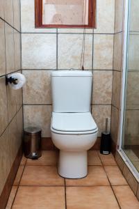 a white toilet in a bathroom with a window at Thaba Legae Guest Lodge in Rustenburg