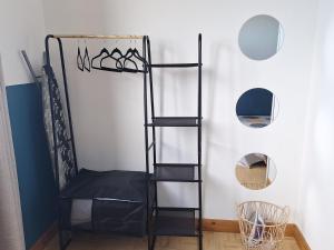 a black book shelf in a room with a mirror at Bungalow tiayo in Saint-Leu