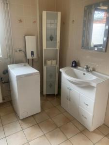 La salle de bains blanche est pourvue d'un lavabo et d'un miroir. dans l'établissement melissa, à Wittingen