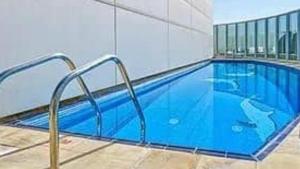 a swimming pool with blue water in a building at Stargazers cozy apartment with direct Metro access in Dubai