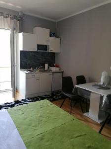 una pequeña cocina con mesa y sillas en una habitación en Villa Juni, en Crikvenica