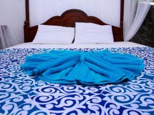 um cobertor azul deitado em cima de uma cama em Easy come Mirissa em Mirissa