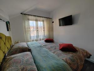een slaapkamer met een bed met 2 kussens erop bij Black&White House in Ocna-Mureşului