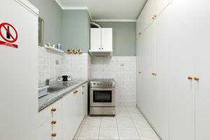cocina con armarios blancos y horno de acero inoxidable en Apartment Stay By Me, en Split