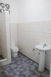 ein Bad mit einem WC und einem Waschbecken in der Unterkunft Crossroads Beach House in Sablayan