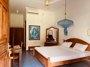 a bedroom with a bed and a table and a mirror at Muthumuni Ayurveda River Resort in Aluthgama