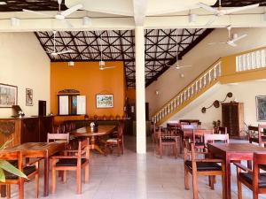 een restaurant met houten tafels en stoelen en een trap bij Muthumuni Ayurveda River Resort in Aluthgama
