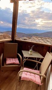 a table and two chairs on a porch with a view at Rooms in Leshten in Leshten