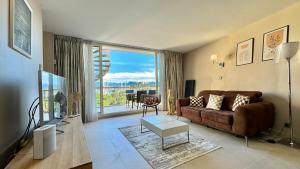 a living room with a couch and a large window at Penthouse vue mer avec Rooftop,Jacuzzi,et parking privé in Antibes