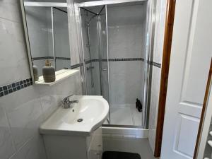 a white bathroom with a shower and a sink at Golden Tours - Studio moderne in Tours