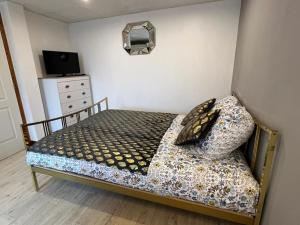 a bed with two pillows and a dresser in a bedroom at Golden Tours - Studio moderne in Tours