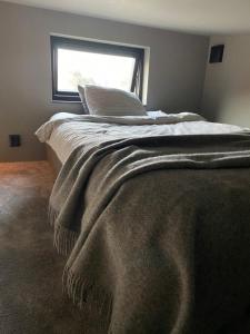 una camera da letto con un letto con una coperta e una finestra di Minihus i Tygelsjö a Tygelsjö
