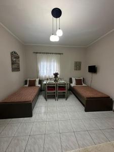 Sala de estar con 2 camas y mesa en Repanidi Apartments, en Repanídhion