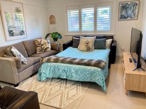 uma sala de estar com um sofá e uma mesa em Family Getaway to Manly Beach plus free onsite parking, stroll to beach, cafes em Sydney