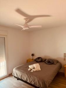 um quarto com uma cama e uma ventoinha de tecto em Casa Pom at the Beach em Torre de Benagalbón