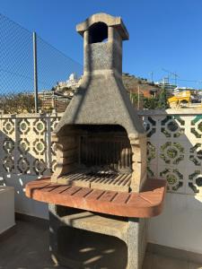 um forno de pedra sentado em cima de uma varanda em Casa Pom at the Beach em Torre de Benagalbón