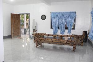 a room with a wooden bench and a window at Crossroads Beach House in Sablayan