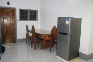 eine Küche mit einem Tisch und einem Kühlschrank in der Unterkunft Crossroads Beach House in Sablayan