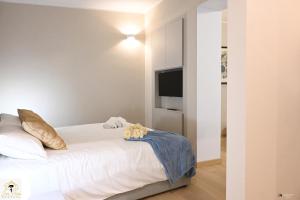 een slaapkamer met een wit bed en een televisie bij Inn Pisa Rentals - Pisa Tower Flat in Pisa