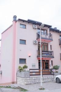 a white building with a balcony on top of it at Apartmani Bašta in Višegrad