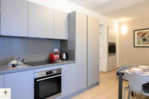 a kitchen with white cabinets and a table in a room at Inn Pisa Rentals - Pisa Tower Flat in Pisa
