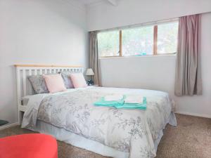 een slaapkamer met een bed met twee handdoeken erop bij Sunny Cosy stay in Auckland in Auckland