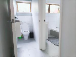 uma casa de banho com um WC, um lavatório e uma banheira em Sunny Cosy stay in Auckland em Auckland