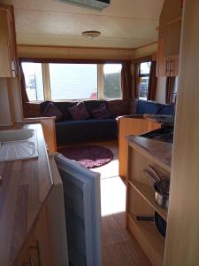 a small kitchen and living room in an rv at Family Fun 2-Bed caravan family romney Marsh in Burmarsh