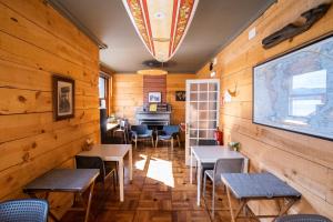 un restaurante con paredes y mesas de madera y un piano en Carving Surf Hostel, en San Esteban de Pravia