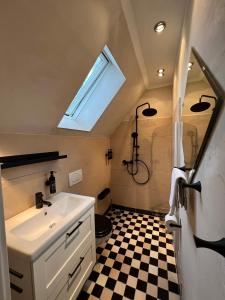 a bathroom with a sink and a shower with a window at Gästewohnung am See in Neuenkirchen