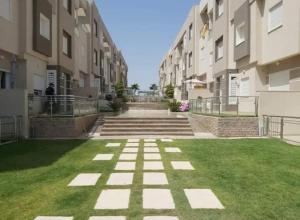 an empty courtyard in a building with grass at Résidence Tilel 2 à Chatt Mariem in Sousse