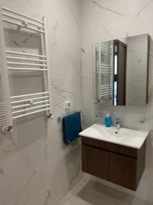 a white bathroom with a sink and a mirror at Résidence Tilel 2 à Chatt Mariem in Sousse