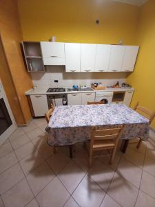 uma cozinha com uma mesa com cadeiras e um fogão em La casetta sul mare em Venetico